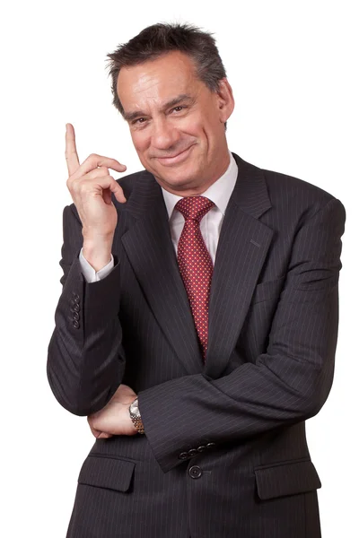 Homem de negócios sorridente de terno apontando para cima — Fotografia de Stock
