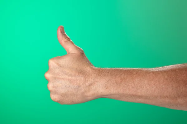 Duimschroef opwaarts ok signaal op groene achtergrond — Stockfoto