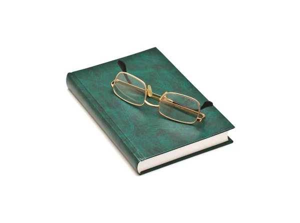 Зеленая книга и очки, изолированные на белом фоне — стоковое фото