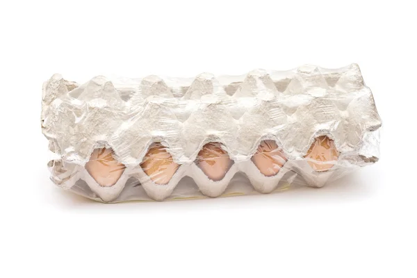 Huevos marrones en un paquete de cartón sobre fondo blanco —  Fotos de Stock