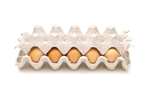 Ovos castanhos numa embalagem de cartão sobre fundo branco — Fotografia de Stock