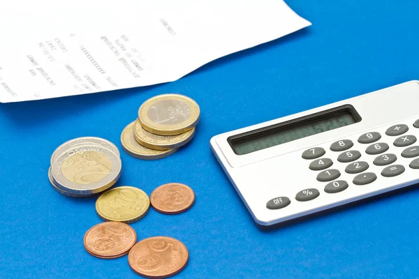 Several euro coins, bill and calculator on blue background — Stock Photo, Image