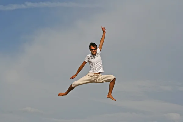 Чоловік стрибає на пляжі — стокове фото