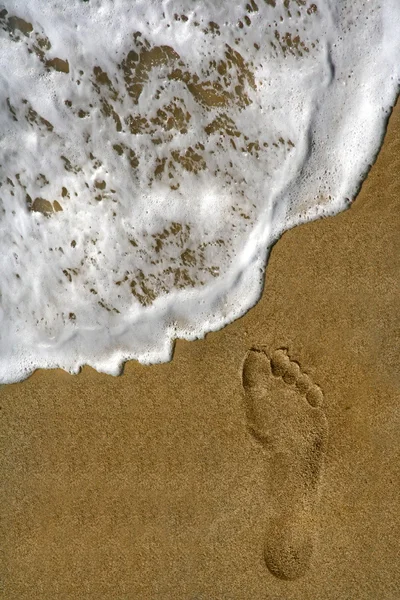 Pegada na areia e na espuma do mar — Fotografia de Stock