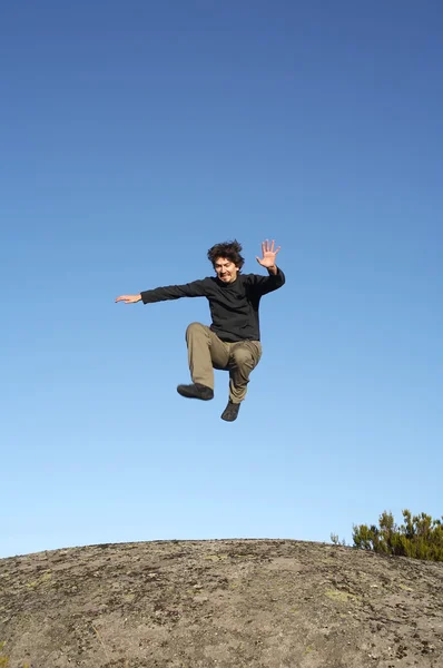 Hombre saltando sobre rocas — Foto de Stock