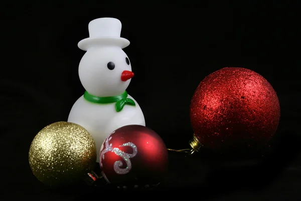 Boneco de neve repousa em uma bola de tração colorida — Fotografia de Stock