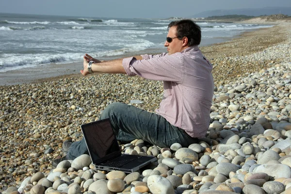 Człowiek z laptopa na plaży — Zdjęcie stockowe