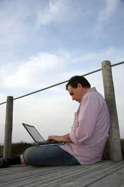 Man met laptop op strand — Stockfoto