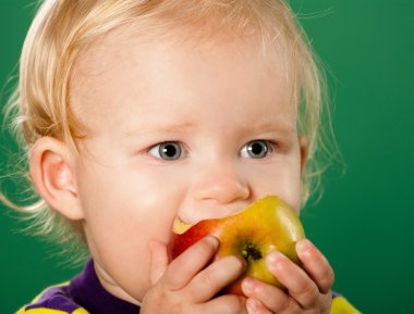 A child with an apple on a green background clipart