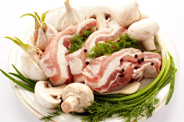 Rauw vlees met paddestoelen, specerijen en kruiden op een pl — Stockfoto