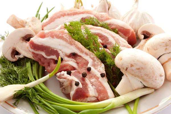 Carne crua com cogumelos, temperos e ervas em um pl — Fotografia de Stock