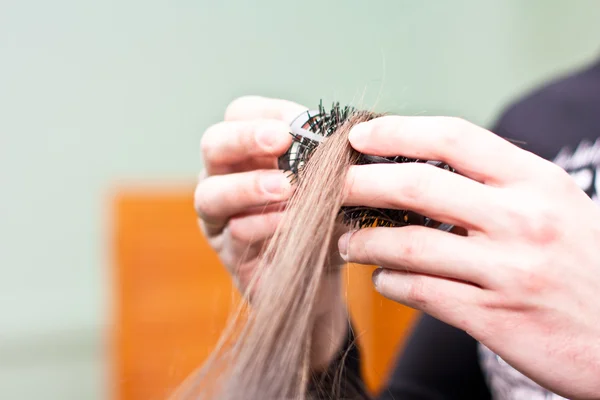 Cabeleireiro enganar o cabelo em um pente — Fotografia de Stock