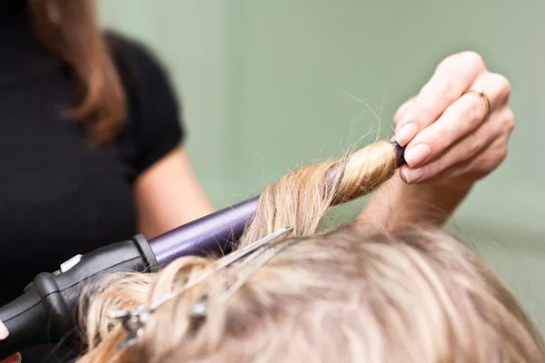 Parrucchiere per arricciare i capelli in un salone di bellezza — Foto Stock