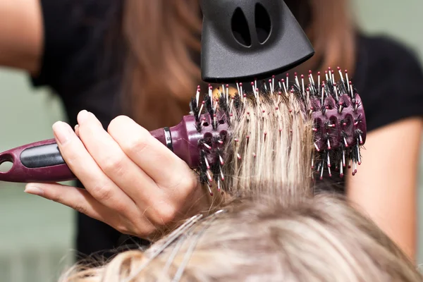 Парикмахер сушит волосы в салоне красоты — стоковое фото