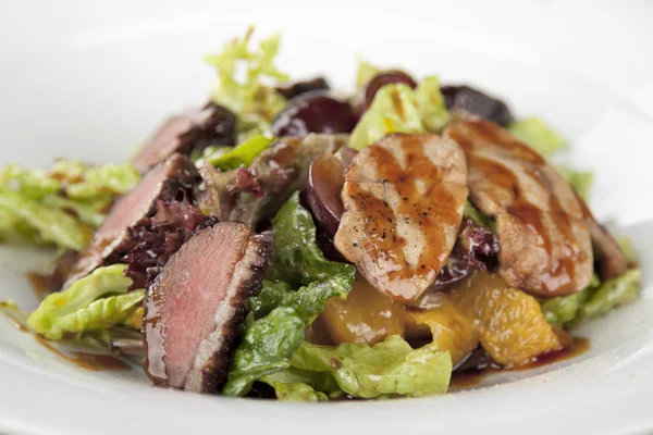 Salade avec viande sur assiette blanche Image En Vente