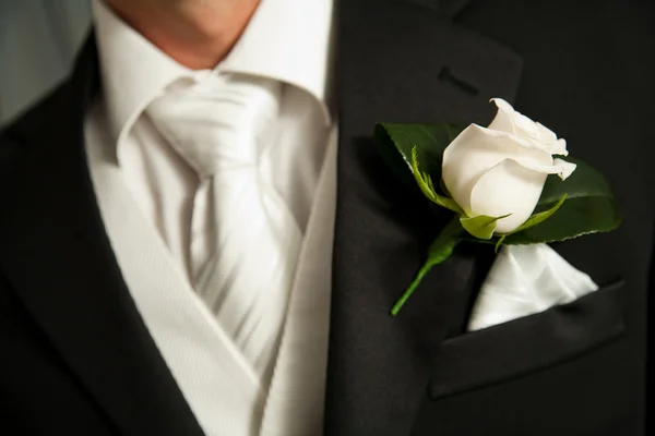 Nahaufnahme einer Korsage aus weißen Rosen an einem Bräutigam — Stockfoto