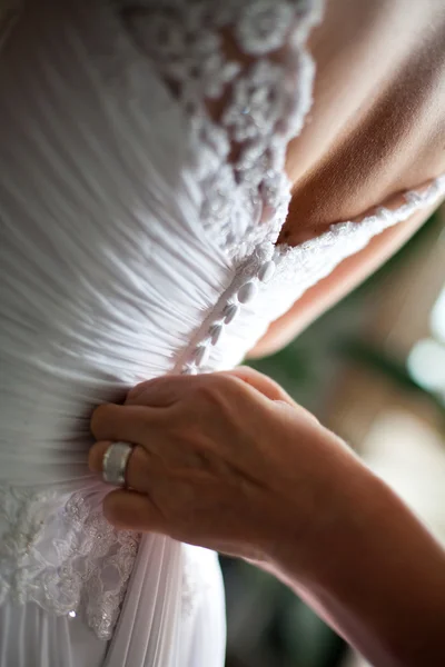 Dos d'une robe de mariée étant boutonné — Photo