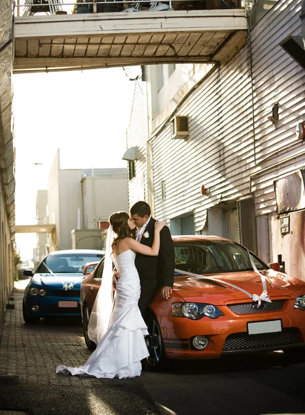Recém-casados beijando apaixonadamente no beco — Fotografia de Stock