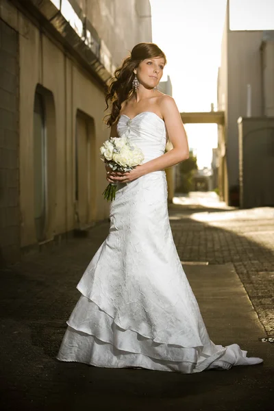 Beautiful bride posing in a grungy alley — Stock Photo, Image