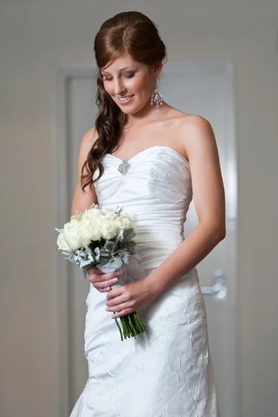Bride holding bouquet and looking down — Stock Photo, Image