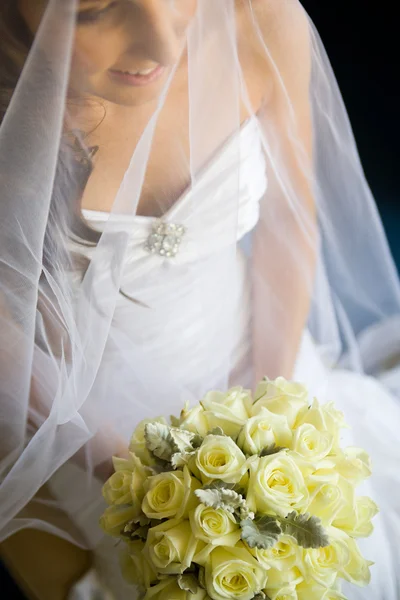 Bride holding her bouquet in lap — Stock Photo, Image