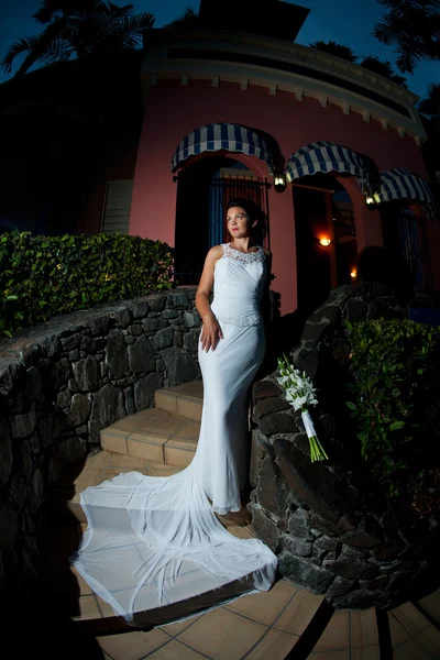 Невеста, стоящая на лестнице с вытянутым вниз платьем Стоковая Картинка