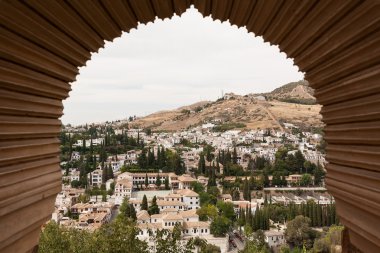 View of Granada through a moorish window of the Alhambra clipart