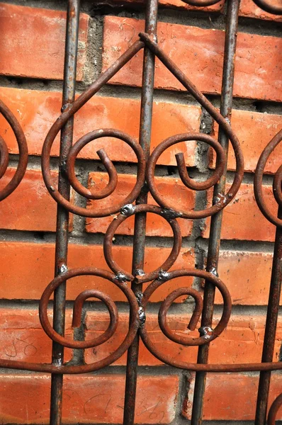 Una pared de ladrillo y valla de metal . — Foto de Stock