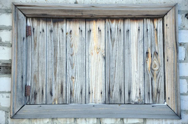 De houten kist op een bakstenen muur. — Stockfoto
