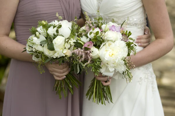 Mariée et demoiselle d'honneur avec des fleurs — Photo