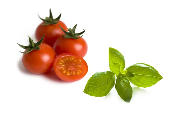 Вишневі помідори та листя базиліка — стокове фото