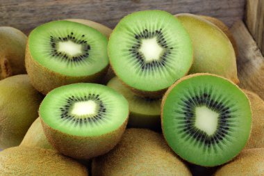 Green kiwi fruit and some cut ones clipart