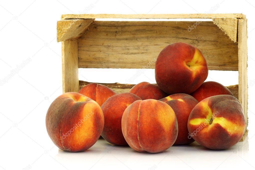 Freshly harvested peaches in a wooden crate