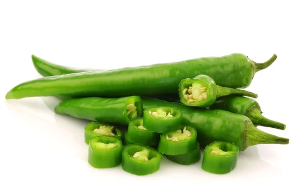 Banda čerstvé zelené chilli papričky a některé řezané kousky — Stock fotografie