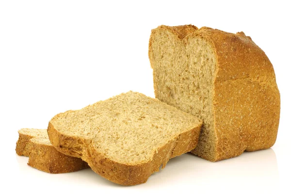 Κόβουμε το καρβέλι ψωμί ολικής αλέσεως και μερικές φέτες — Φωτογραφία Αρχείου