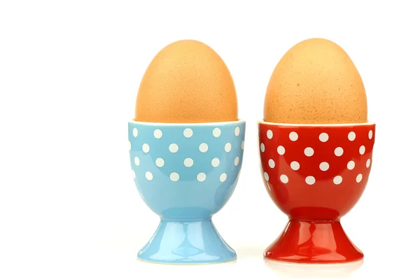 Colorful and decorated blue and white and red and white egg cups with eggs — Stock Photo, Image