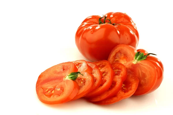 Sliced beef tomato and a whole one — Stock Photo, Image