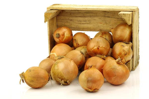 stock image Bunch of brown onions coming from a wooden box