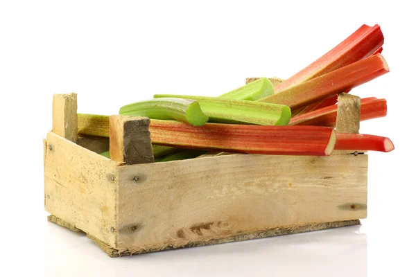 Fresh stems of rhubarb in a wooden box — Stock Photo, Image