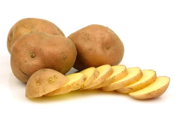 Bunch of potatoes and a sliced one — Stock Photo, Image