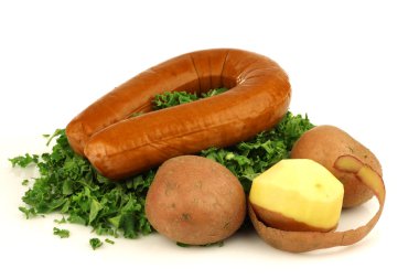 Freshly cut kale cabbage, some potatoes and a smoked sausage clipart