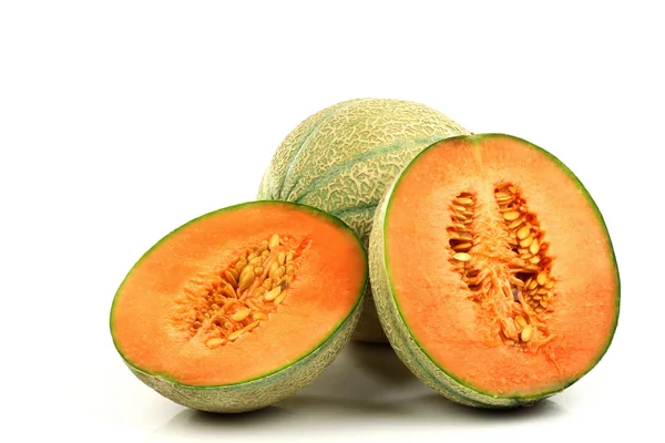 One whole cantaloupe melon and two halves — Stock Photo, Image
