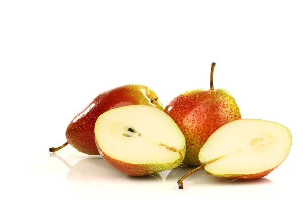A fresh red and yellow pear and two halves — Stock Photo, Image
