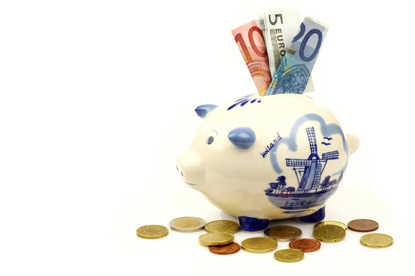 Ceramic Delft Blue piggy bank with euro paper money and coins — Stock Photo, Image
