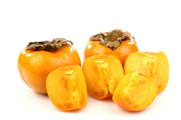 Two persimmon fruit and one sliced — Stock Photo, Image