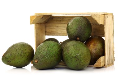 Fresh and ripe avocado's in a wooden crate clipart