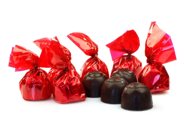 Une rangée de bonbons enveloppés dans du papier rouge brillant — Photo