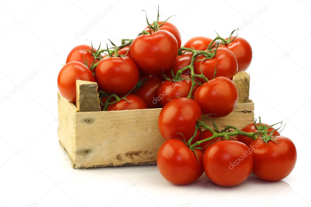 Fresh tomatoes on the vine in a wooden crate