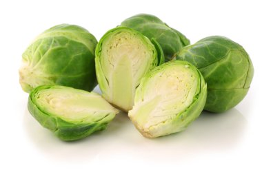 Freshly cut brussel sprouts and some whole ones clipart