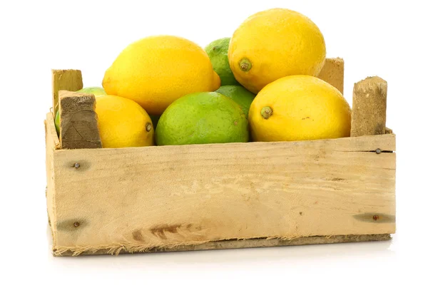 Fresh lemons and lime fruits in a wooden box — Stock Photo, Image